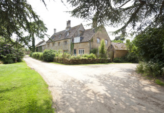 Stort landsted omgivet af grønne områder på Feather Down Hidcote Manor Farm, feriepark i West Midlands, UK.
