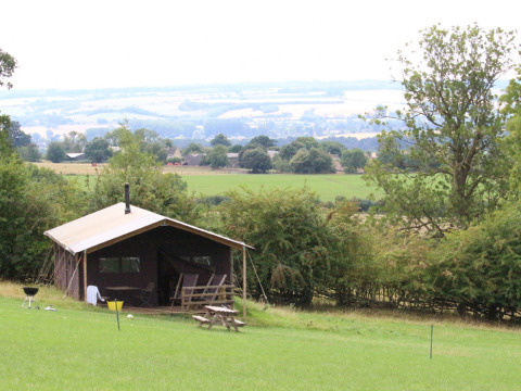 Knusse hut met uitzicht op groene weiden bij Feather Down Hidcote Manor Farm in West Midlands, Verenigd Koninkrijk.