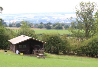 Knusse hut met uitzicht op groene weiden bij Feather Down Hidcote Manor Farm in West Midlands, Verenigd Koninkrijk.