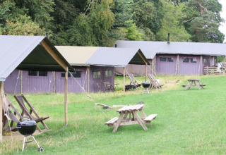 Glampingtenten en picknickbanken bij Feather Down Hidcote Manor Farm vakantiepark in West Midlands, Verenigd Koninkrijk.