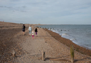 Famiglia che passeggia su una spiaggia di ciottoli a Feather Down Lunsford Farm, nel sud-est dell’Inghilterra.
