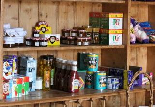 Hylder med britiske dagligvarer, herunder Heinz Beanz, Marmite, ketchup og PG Tips te i en butik.