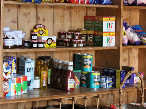 Scaffali con prodotti alimentari britannici come Heinz Beanz, Marmite, ketchup e tè PG Tips in un negozio.