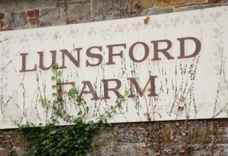 Skilt ved Lunsford Farm med vinstokke, fotograferet på Feather Down Lunsford Farm i Sydøstengland, UK.