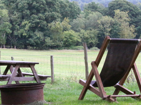 Buitenzicht bij BoerenBed Sunninglye Farm met strandstoel, picknicktafel en veld in Oost-Engeland, VK.