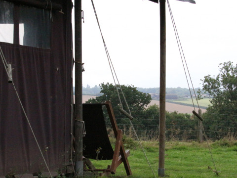 Zicht vanuit een tent bij BoerenBed Sunninglye Farm, velden en bomen op de achtergrond, East of England.