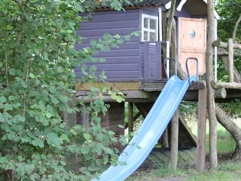 Boomhut met blauwe schuifaf en omgeven door groen, bij BoerenBed Sunninglye Farm in Engeland genomen.