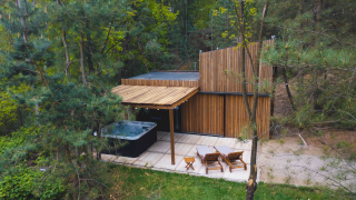 Træhytte Comfort Sweet Wellness med udendørs spa og loungeområde i skovene i Limburg, Belgien.