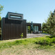 Sort træhytte i naturskønne omgivelser ved Holiday park De Klepperstee, Kleproos Lodge, Nederlandene.