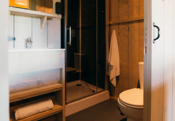 Badkamer in het Safari cottage tent op Holiday Park Sallandshoeve in Nederland met douche en toilet.