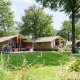 Rheezerlodge DeLuxe low en Kampeerdorp de Zandstuve, Países Bajos, rodeado de césped y naturaleza.
