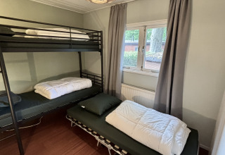 Kamer met stapelbed en eenpersoonsbed in Cozy Chalet in Bungalowpark Het Verscholen Dorp, Nederland.