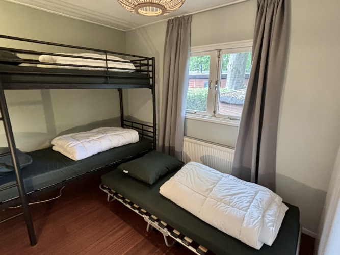 Habitación con litera y cama individual en Cozy Chalet, Bungalowpark Het Verscholen Dorp, Países Bajos.