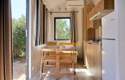 Lys og moderne indretning af Tiny Home Arrozal på TAIGA Delta de l'Ebre, Spanien, med køkken og spiseplads.