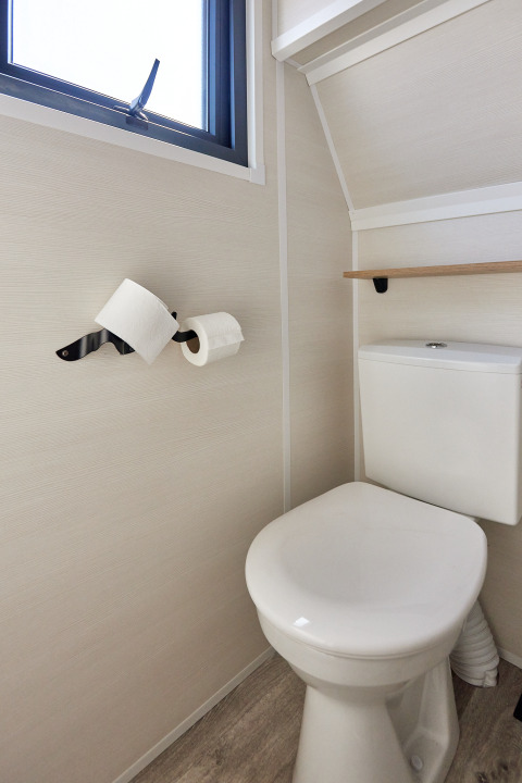 Compact bathroom with toilet and two toilet paper rolls on wall, Tiny Home Arrozal at TAIGA Delta de l'Ebre.