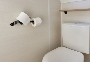 Et lille badeværelse med toilet og to toiletpapirruller på væggen, Tiny Home Arrozal, TAIGA Delta de l'Ebre.