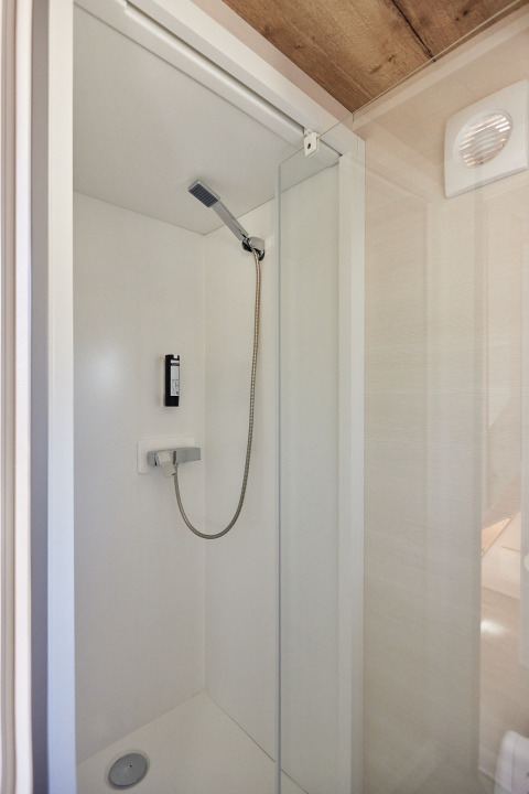 Ducha moderna y pequeña con puerta de cristal en Tiny Home Arrozal, TAIGA Delta de l'Ebre, España.