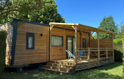 Lodge Prestige Cottage al Camping Seasonova Les Marguerites in Francia, circondato dal verde e cielo sereno.