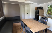 Binnenzicht van Prestige Cottage op Camping Seasonova Les Marguerites in Frankrijk met eethoek.