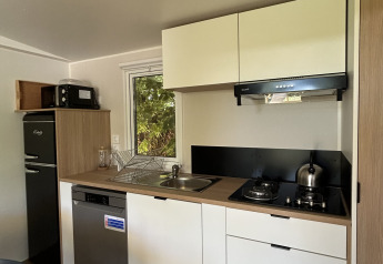 Moderne tekøkken i Prestige Cottage hos Camping Seasonova Les Marguerites i Frankrig med hvide skabe.