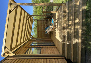 Prestige Cottage en Camping Seasonova Les Marguerites en Francia, con terraza de madera y tumbonas al sol.