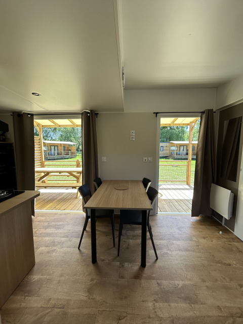 Indvendig udsigt af en hytte ved Cottage på Camping Seasonova Les Marguerites med bord og stole.
