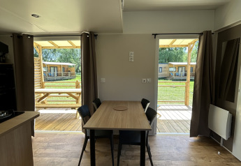 Indvendig udsigt af en hytte ved Cottage på Camping Seasonova Les Marguerites med bord og stole.