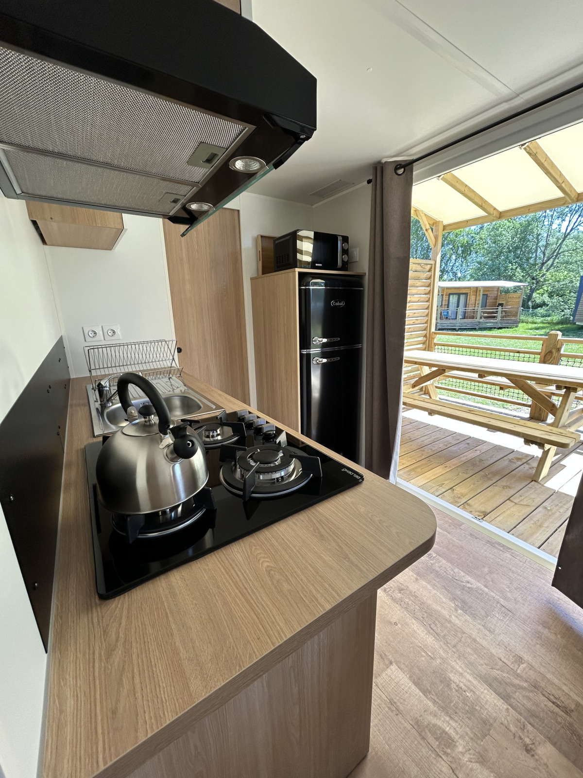 Moderne keuken in een cottage bij Camping Seasonova Les Marguerites in Frankrijk, met uitzicht op terras.