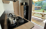 Angolo cottura moderno in un cottage al Camping Seasonova Les Marguerites, Francia, con terrazza esterna.
