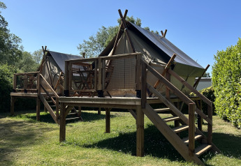 Safaritent Nomads Bivoac op Camping Seasonova Les Marguerites in Frankrijk met houten terras en trap.