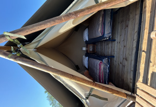 Interieur van de Nomads Bivoac safaritent met twee bedden op Camping Seasonova Les Marguerites in Frankrijk.