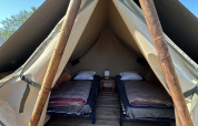 Vista interior de la tienda safari Nomads Bivoac con dos camas en Camping Seasonova Les Marguerites, Francia.
