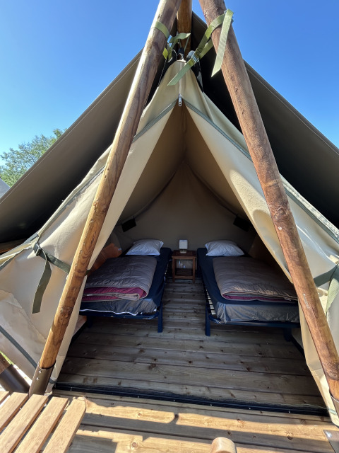 Vue intérieure de la tente safari Nomads Bivoac avec deux lits au Camping Seasonova Les Marguerites en France.
