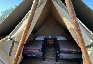 Interior view of Nomads Bivoac safari tent with two beds at Camping Seasonova Les Marguerites in France.