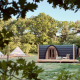 A cozy modern cabin and canvas tents in a tranquil forest setting, surrounded by lush green trees.