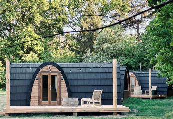 Knusse hutten met gebogen dak en houten veranda bij Cabin at Thuysgrond in Nederland, zomers uitzicht.