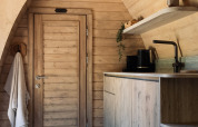 Træbeklædt interiør af en komfur og dør i Cabin at Thuysgrond, Holland, hyggeligt og moderne design.