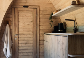 Træbeklædt interiør af en komfur og dør i Cabin at Thuysgrond, Holland, hyggeligt og moderne design.