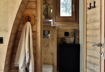 Baño de madera con toalla, inodoro y ventana en una cabaña en Thuysgrond, Países Bajos.
