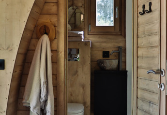 Holzbad in einer Kabine mit Handtuch, Toilette und Fenster im Cabin at Thuysgrond, Niederlande.