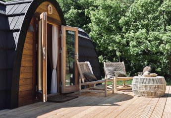 Terrasse extérieure de la cabine Cabin at Thuysgrond aux Pays-Bas avec deux fauteuils et une table.