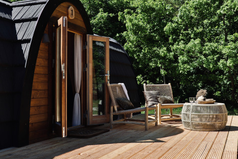 Terrazza esterna della Cabin at Thuysgrond nei Paesi Bassi con due sedie e un tavolino in legno.