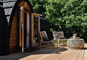Terrasse extérieure de la cabine Cabin at Thuysgrond aux Pays-Bas avec deux fauteuils et une table.
