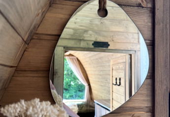 Spiegelbeeld in een houten hut bij Cabin at Thuysgrond, Nederland, weerspiegelt een knus interieur.