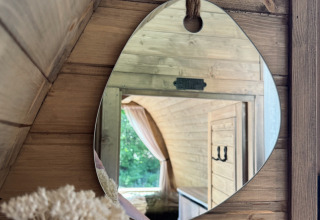 Spiegelbeeld in een houten hut bij Cabin at Thuysgrond, Nederland, met zicht op een gezellig interieur.