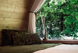 Letto accogliente in una cabina di legno con finestra aperta e vista sulla foresta, Cabin at Thuysgrond, Paesi Bassi.