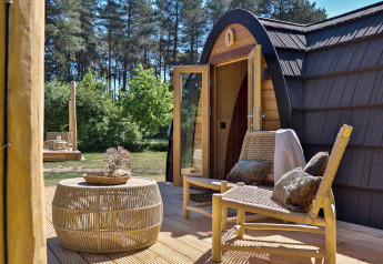 Udendørs terrasse ved Cabin at Thuysgrond, Nederlandene med flettede stole og bord midt i naturen.