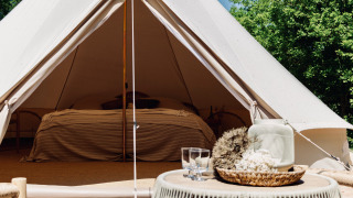 Komfortables Bell-Zelt mit gemütlichem Bett und geschmackvoller Einrichtung, ideal zum Glamping.
