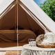Luksuriøs Bell-tipi med komfortabel seng, rustik indretning og udsigt til natur, perfekt til glamping.