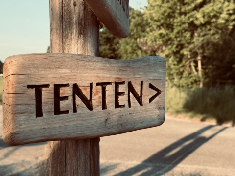 Houten bord met ‘TENTEN’ en pijl naar rechts, genomen bij Bell tent op Thuysgrond in Nederland.